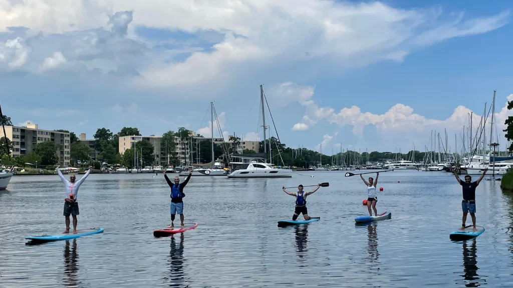 Paddlers on the water holding up their paddles