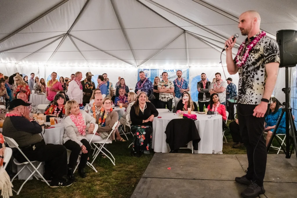 The LiveWater president speaks to the crowd in a large white event tent.