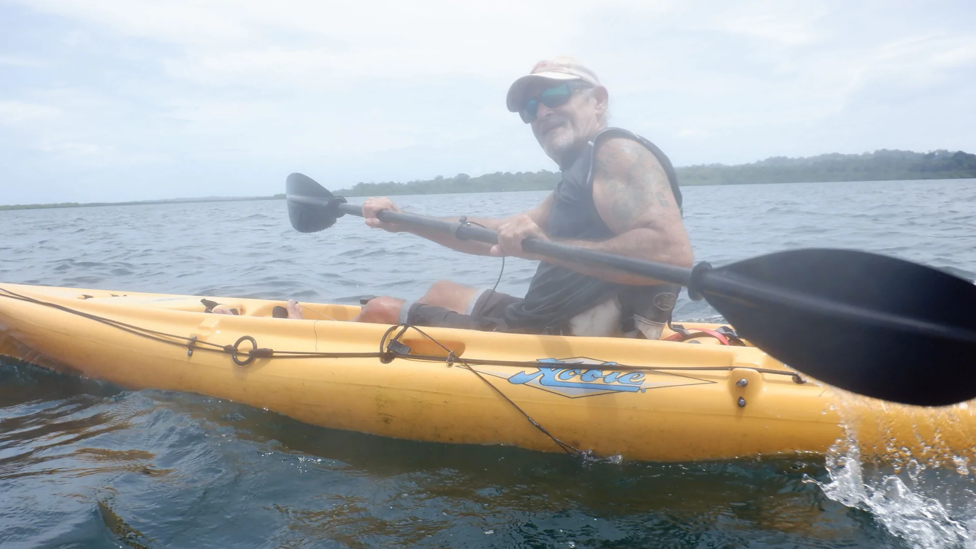 The author looks into the camera as he paddles a kayak