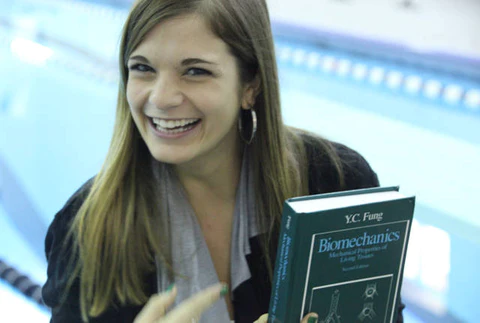 Erika by a pool holding a book