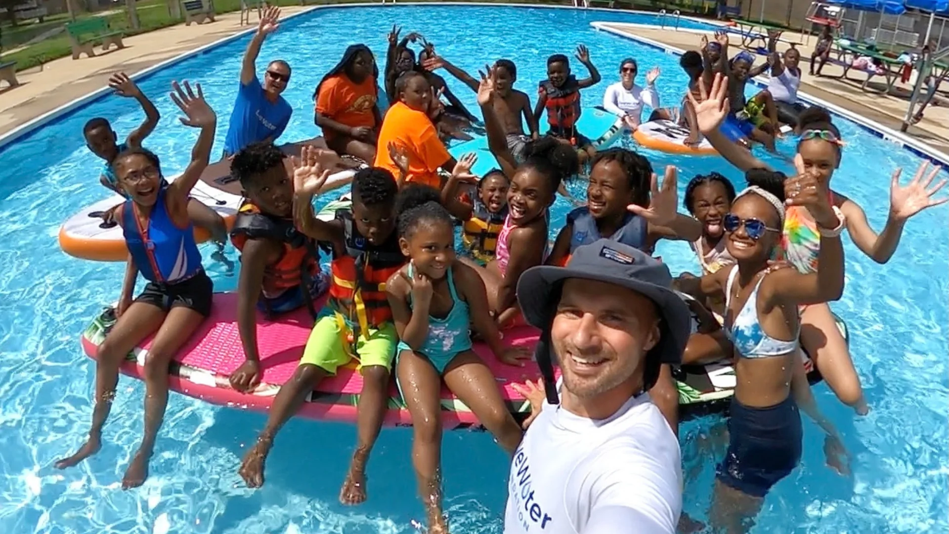 The Live Water president takes a selfie with a bunch of kids in a pool