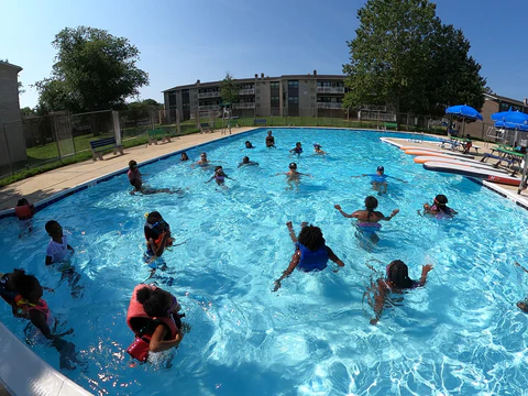 A pool filled with kids floating and playing