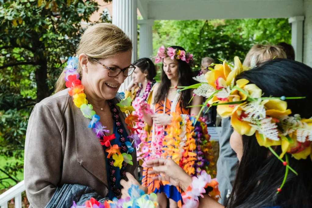A woman hands out flower leis