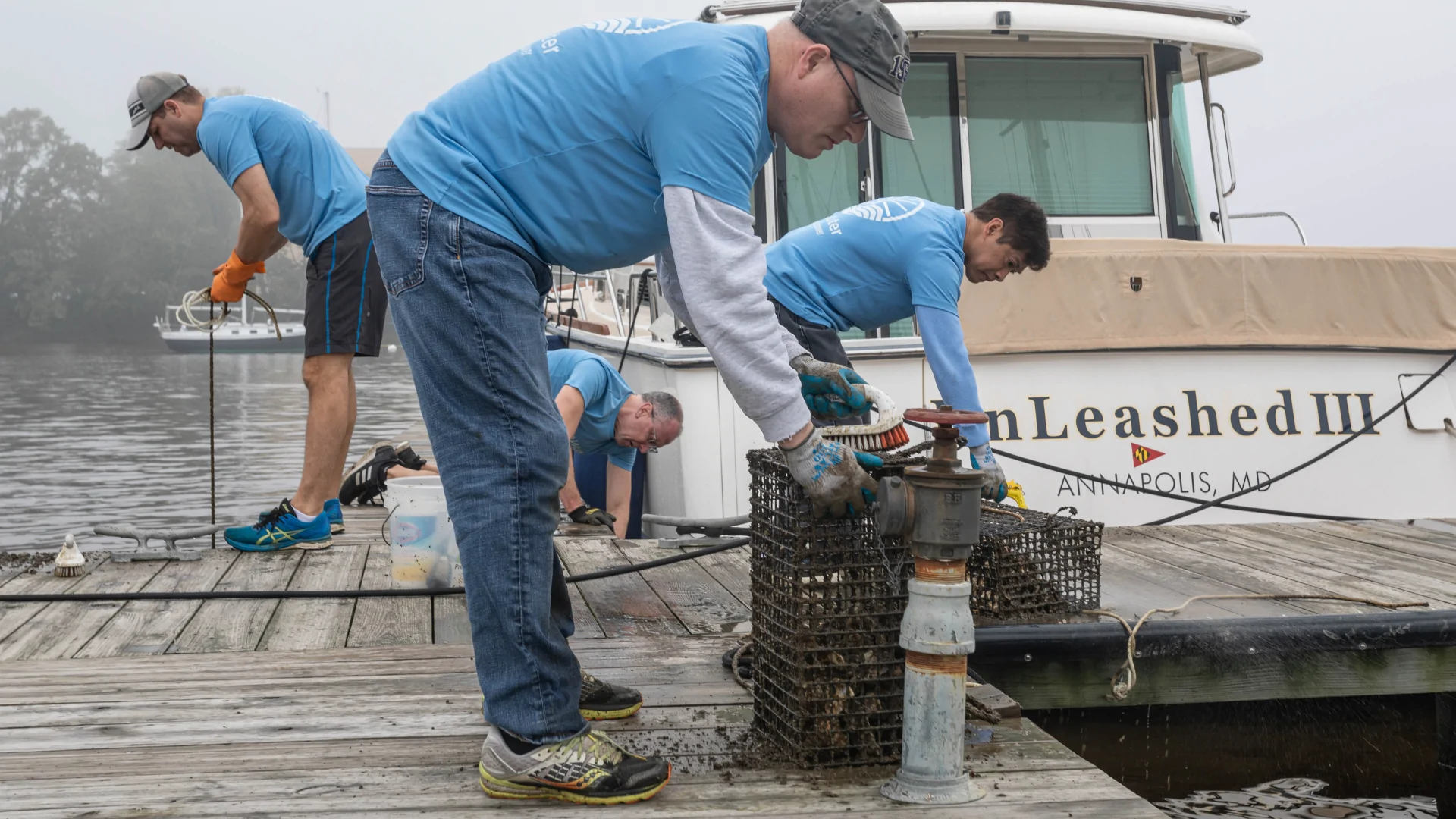 three men on a pier wearing blue LWF t-shirts service oyster cages