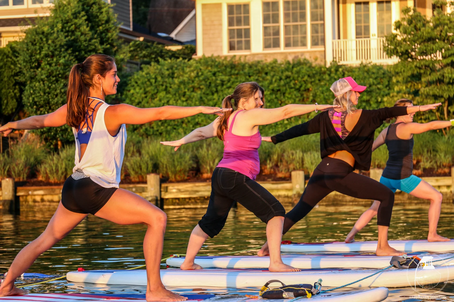 three women doing a warrior pose on paddleboards